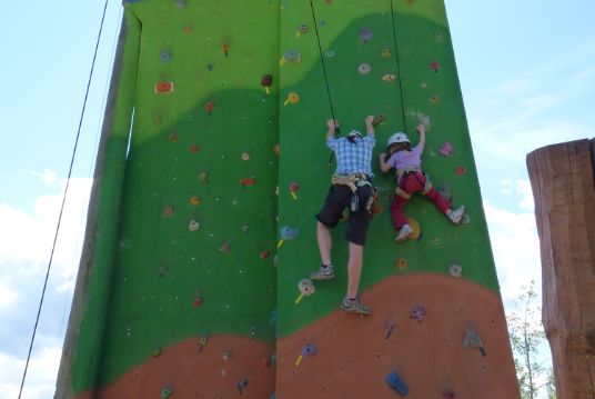 a woman and a child on a climbing wall